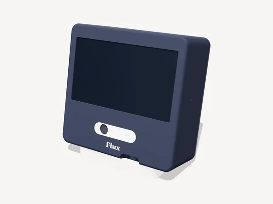 A render of Flux: a navy box with a 7 inch screen, a cream sensor pill and the Flux wordmark, leaning back on a cream stand.